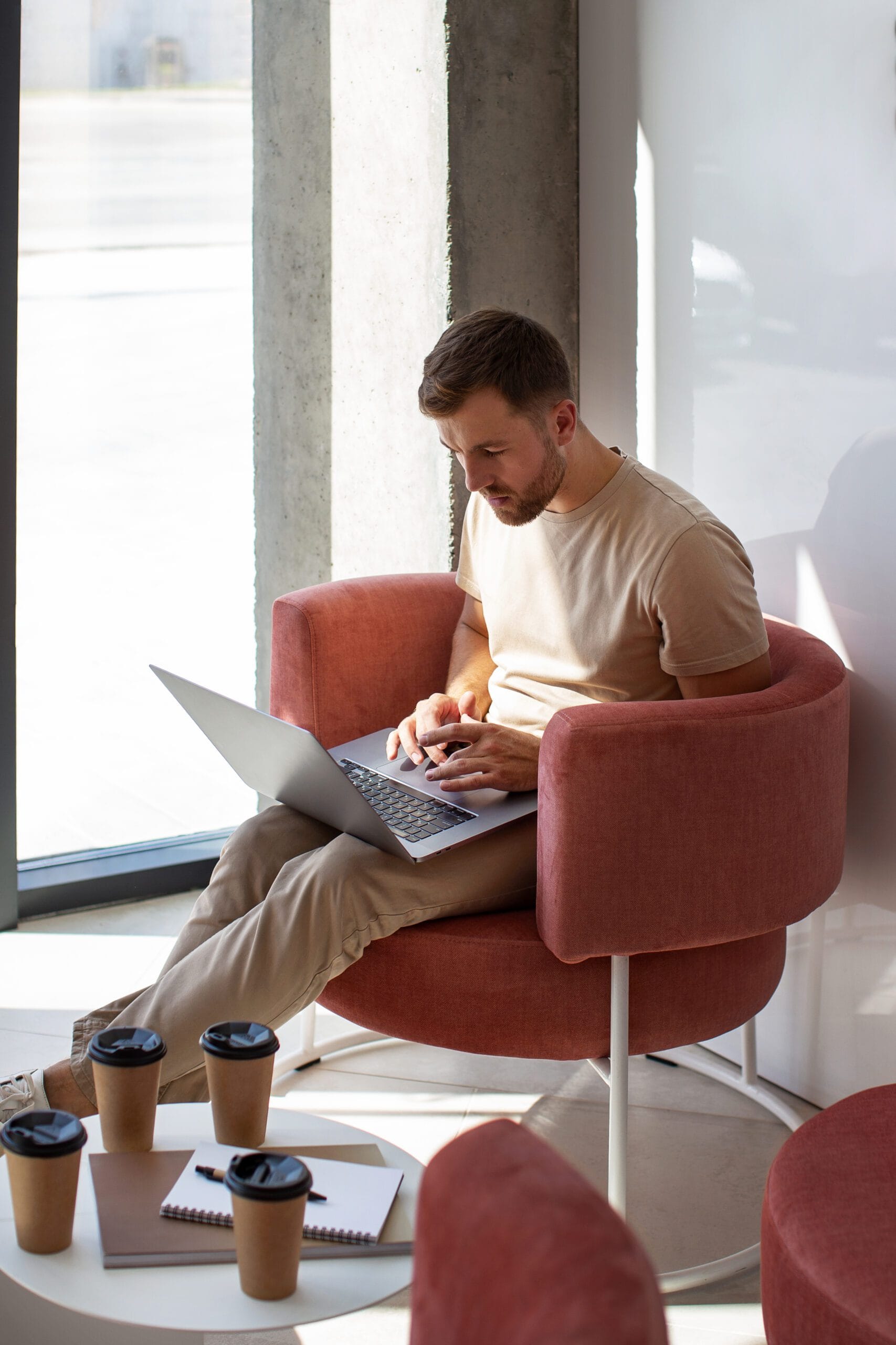 Pracownik biura rachunkowego pracuje nad dokumentami księgowymi na laptopie w kawiarni.
